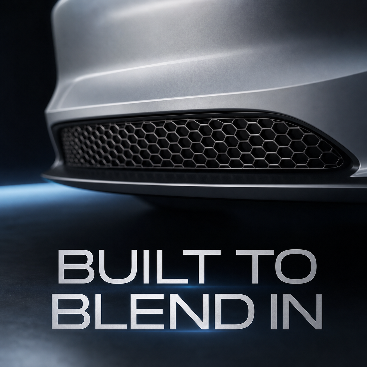 Close-up of a low-profile black honeycomb screen blending into a silver lower intake